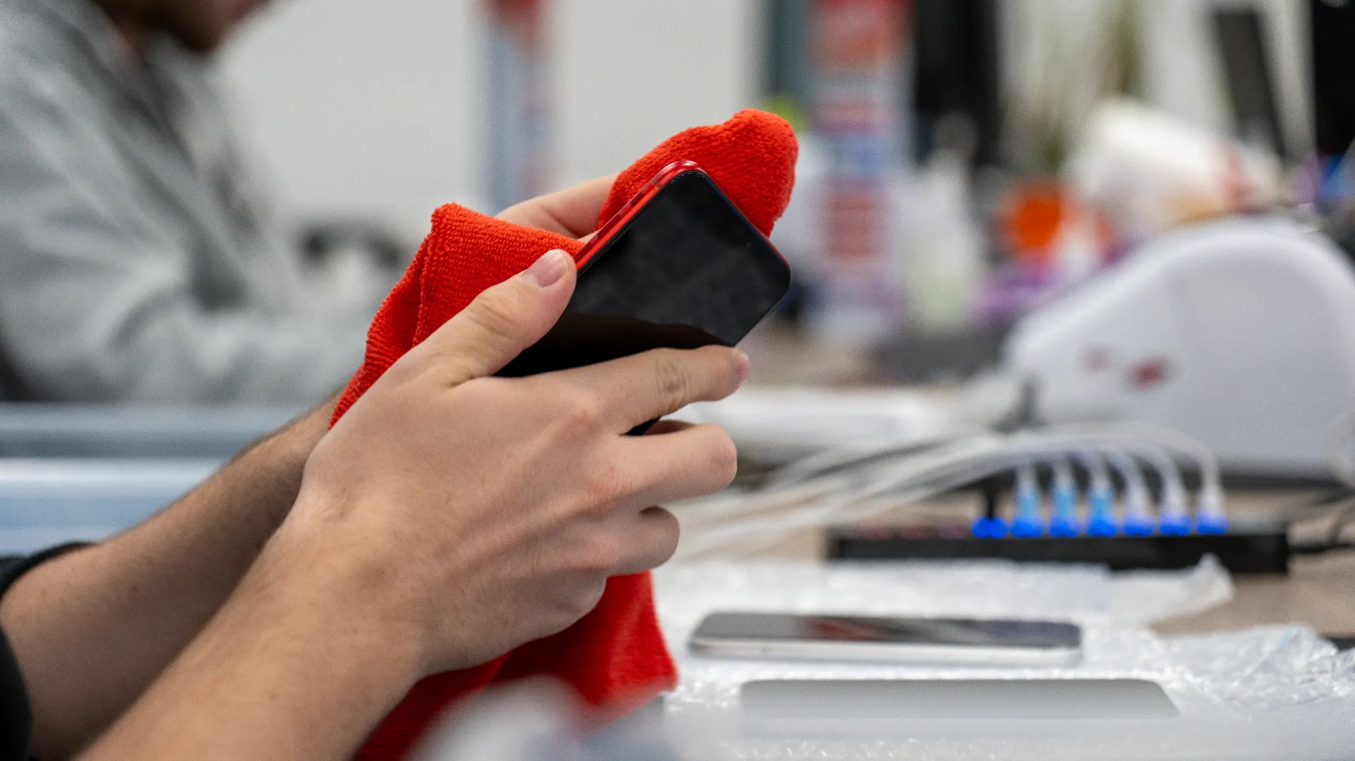 Technicien nettoyant un smartphone reconditionné